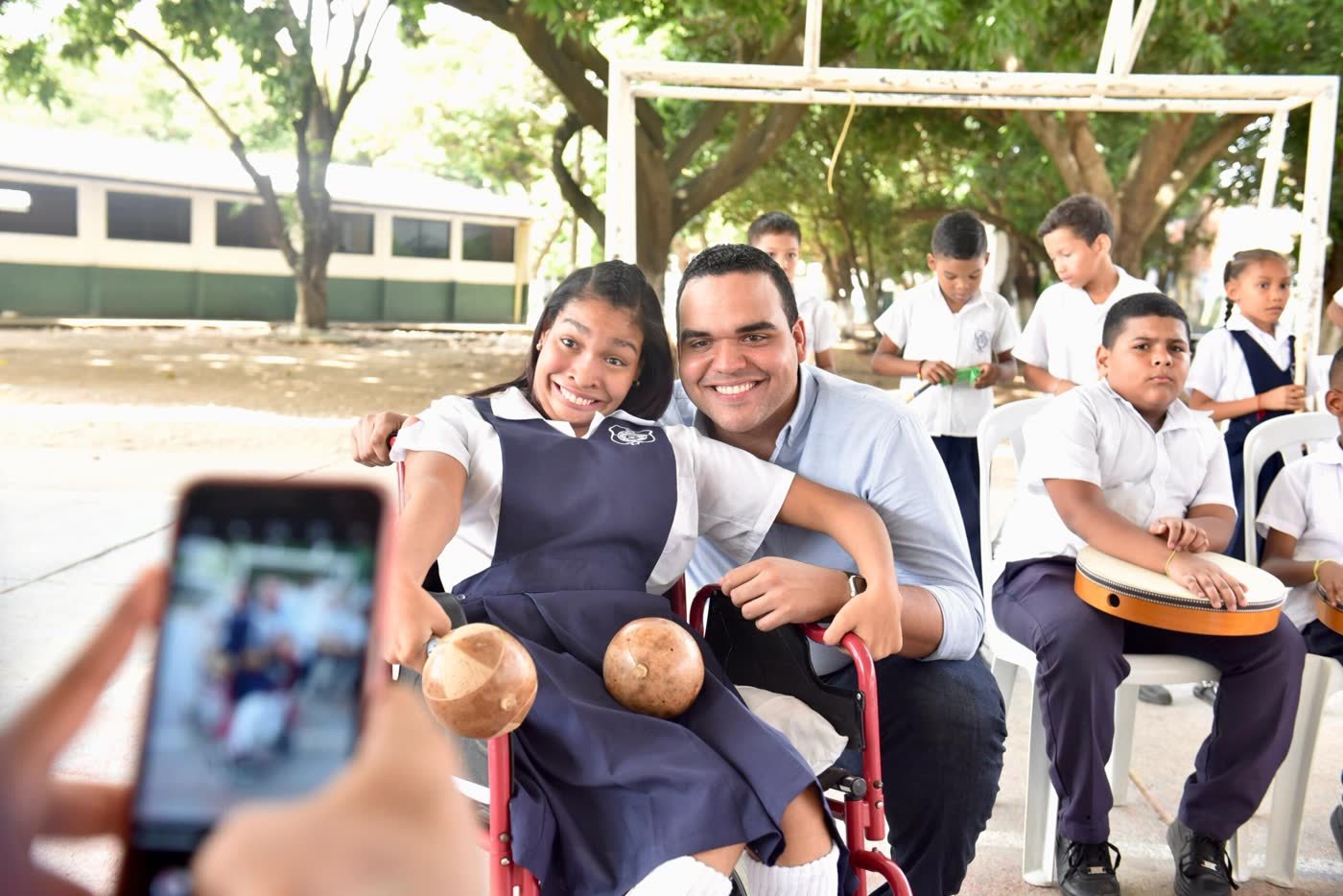 Un docente acompaña a una estudiante durante una actividad musical
