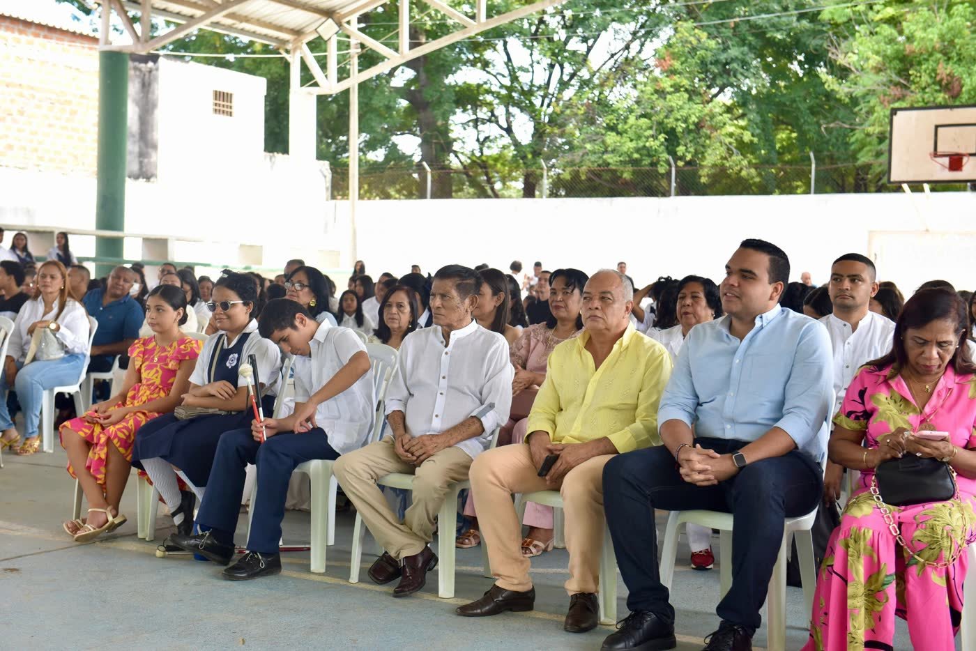 Padres, acudientes y estudiantes asisten a un acto institucional en la cancha del colegio